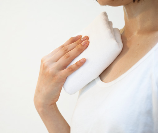 タオルで汗を拭く女性