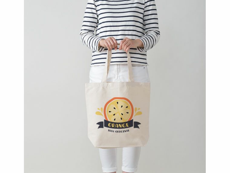 手に持ったキャンバストート(ML) ナチュラルと名入れイメージ