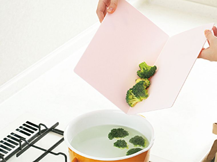 たためる まな板を二つ折りで食材を鍋に移す